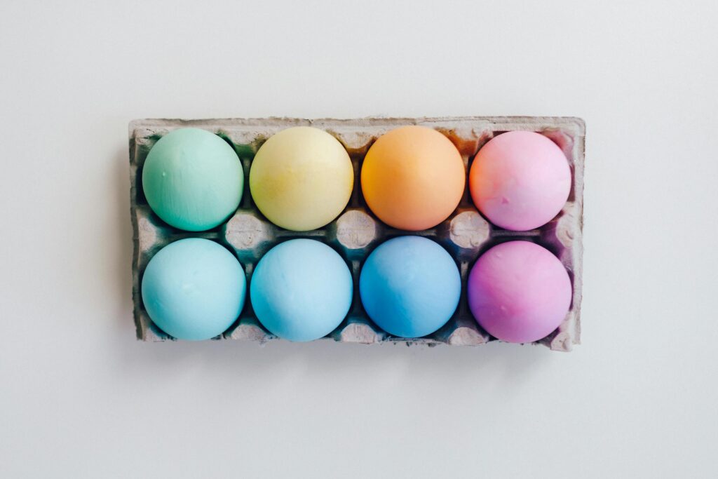 A set of vibrant pastel Easter eggs arranged in a carton, perfect for festive decoration.